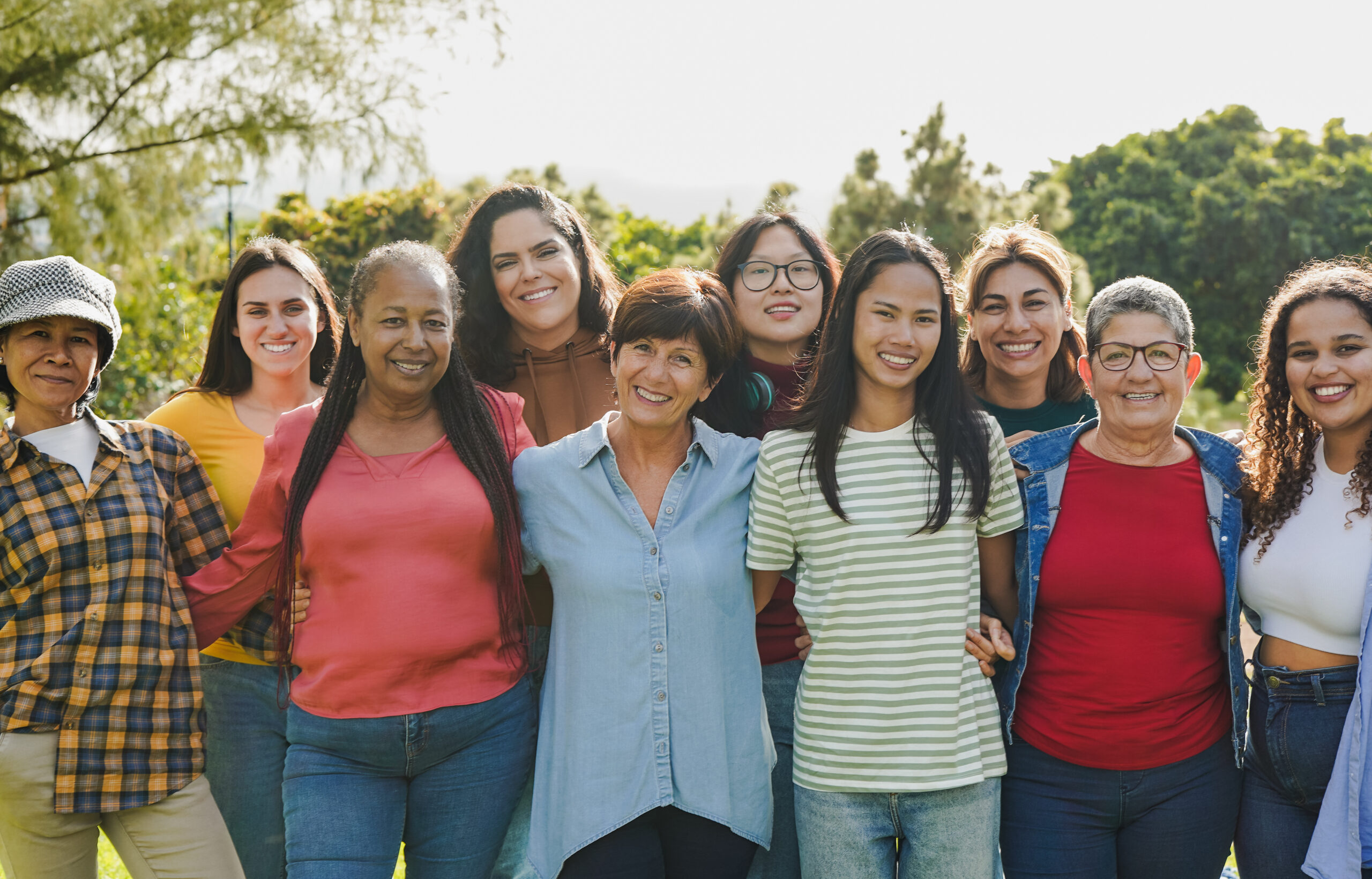 Group of multi generational women hugging each other while smili