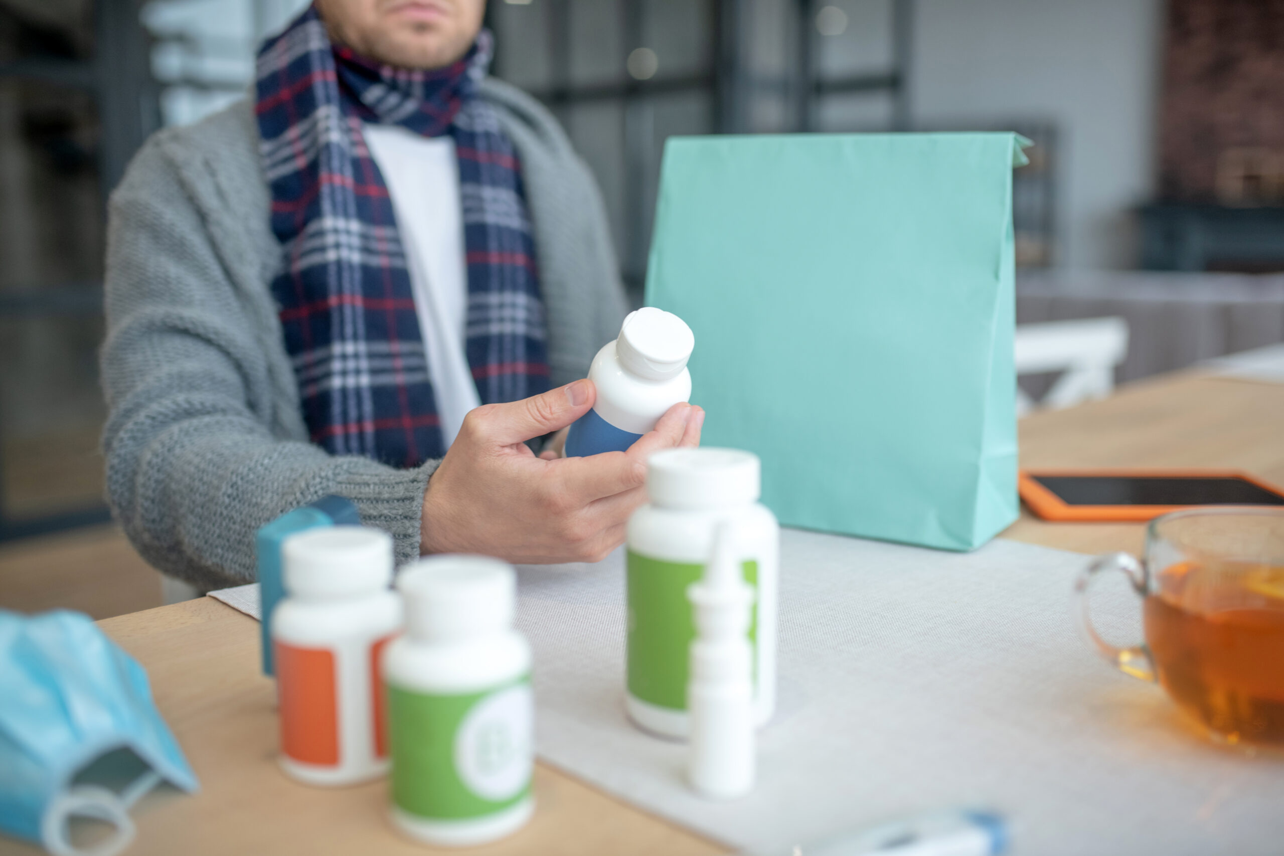 Sick man reading description of pills attentively
